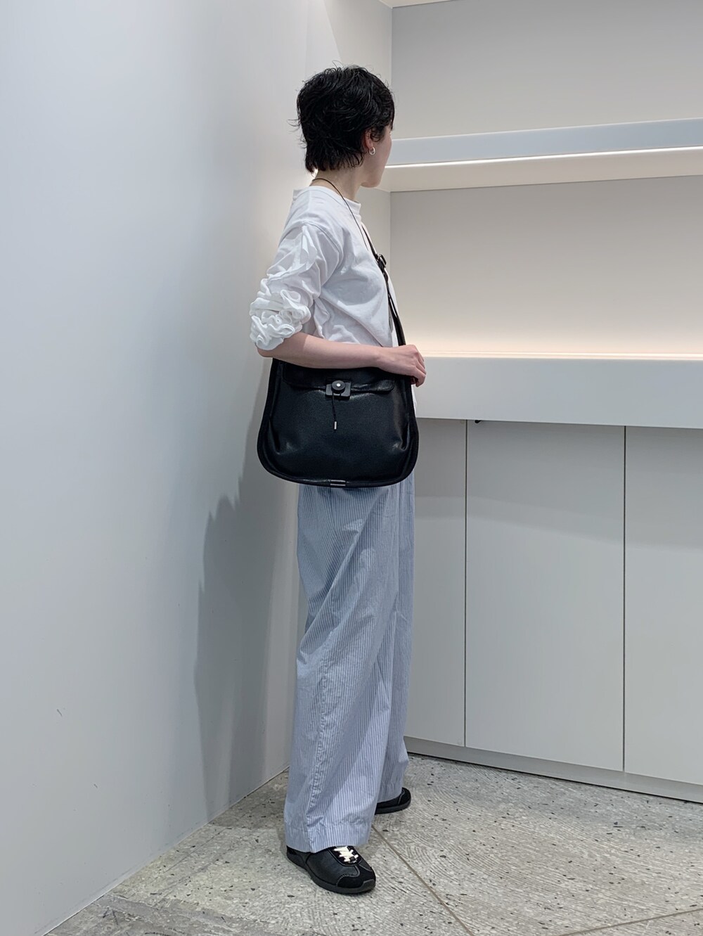 ブルー系のショルダーバッグ、ブラック系のショルダーバッグを着用したレディースの夏コーディネートの2枚目の写真