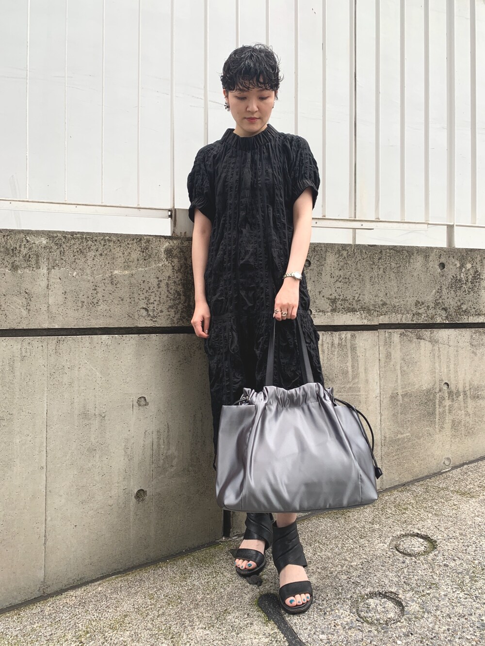 グレー系のトートバッグを着用したレディースの夏コーディネートの2枚目の写真