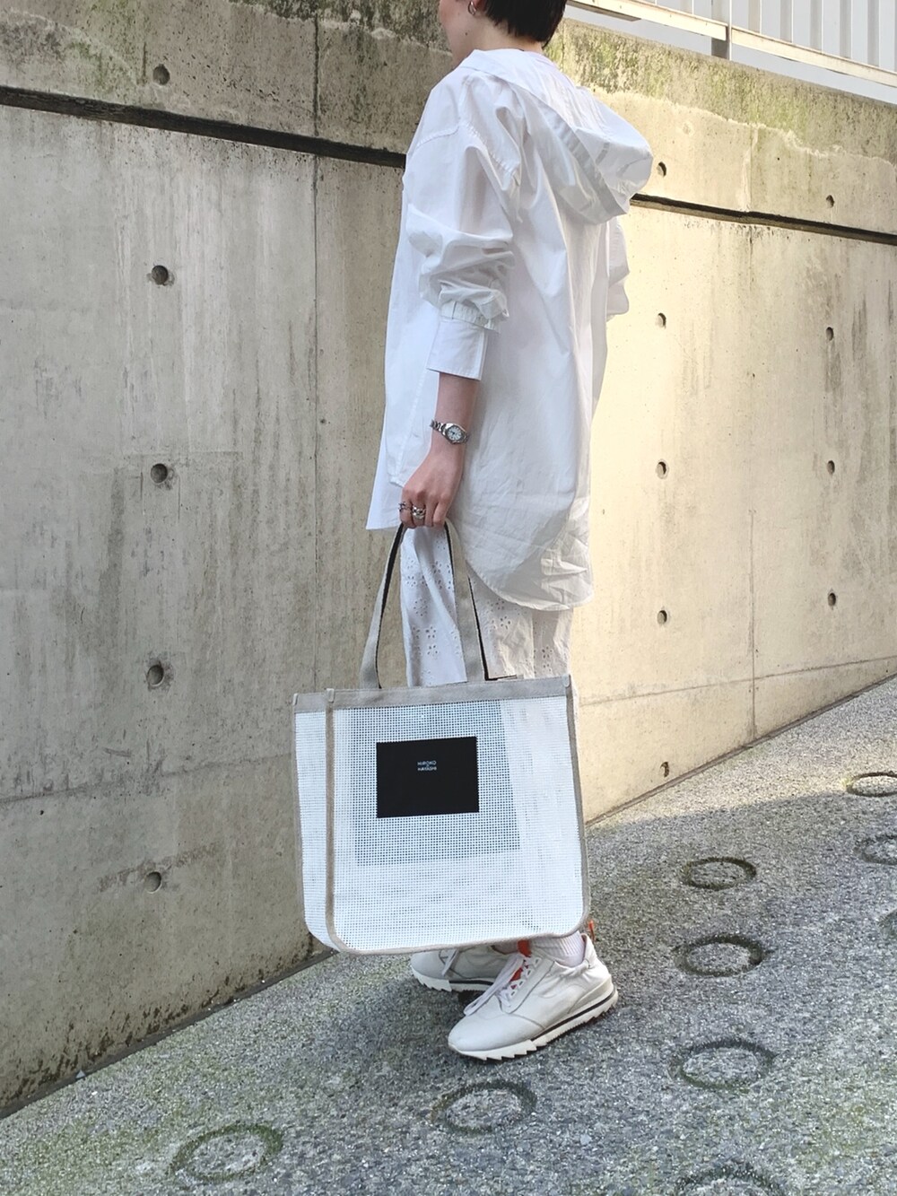 ホワイト系のトートバッグを着用したレディースの夏コーディネートの2枚目の写真
