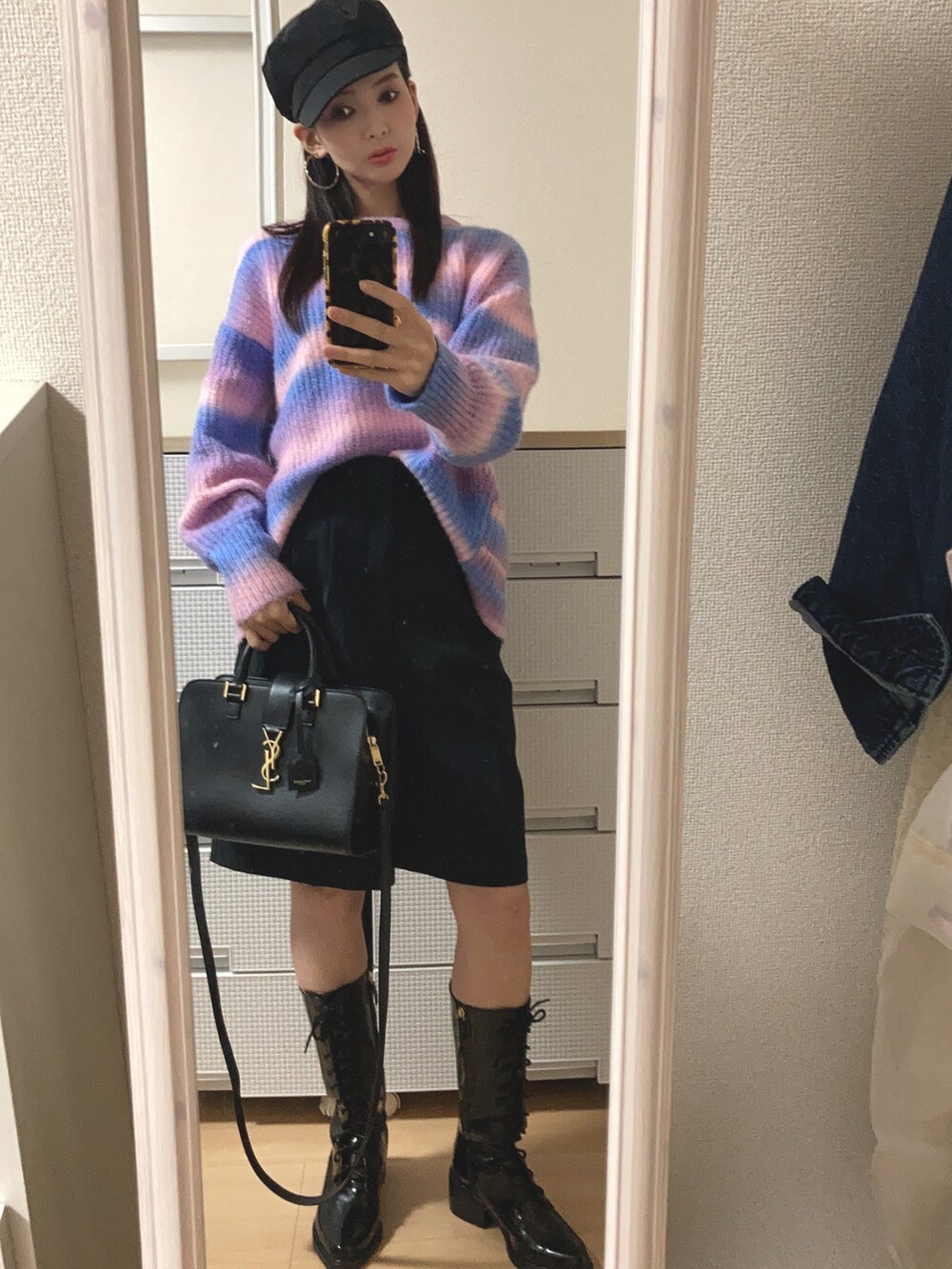 パープル系のニット/セーター、ブラック系のパンツ、ブラック系のブーツを着用したレディースの秋コーディネートの2枚目の写真