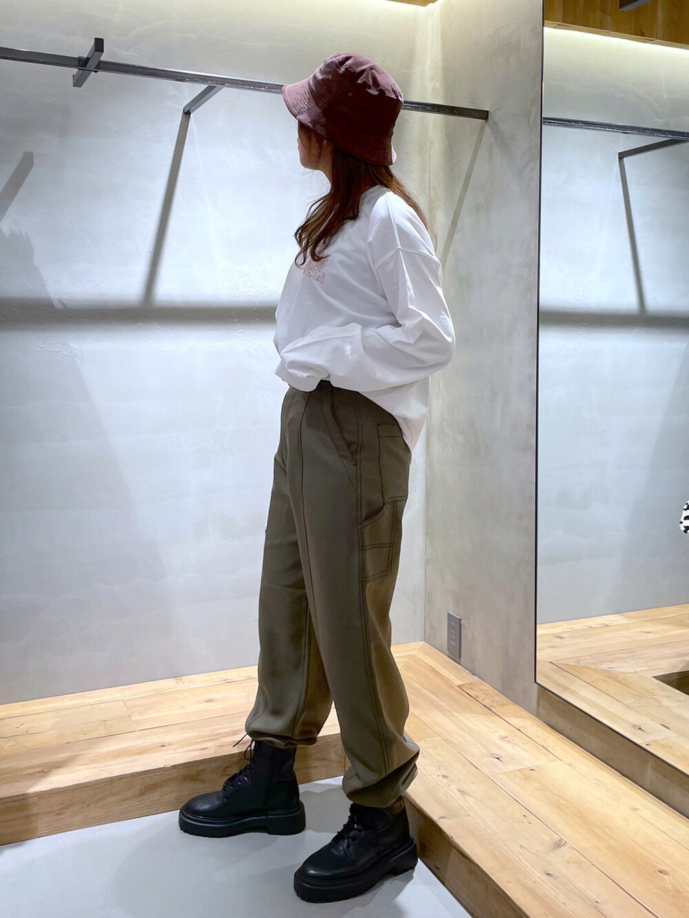 ホワイト系のTシャツ/カットソー、グリーン系のその他パンツ、ブラック系のブーツを着用したレディースの秋コーディネートの2枚目の写真