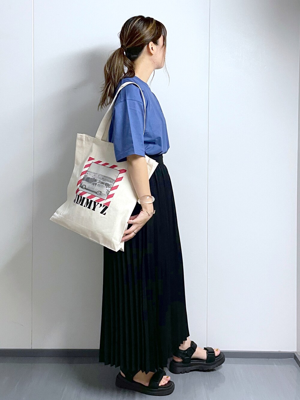 ブラック系のサンダル、ブラック系のスカート、ホワイト系のトートバッグを着用したレディースの夏コーディネートの3枚目の写真