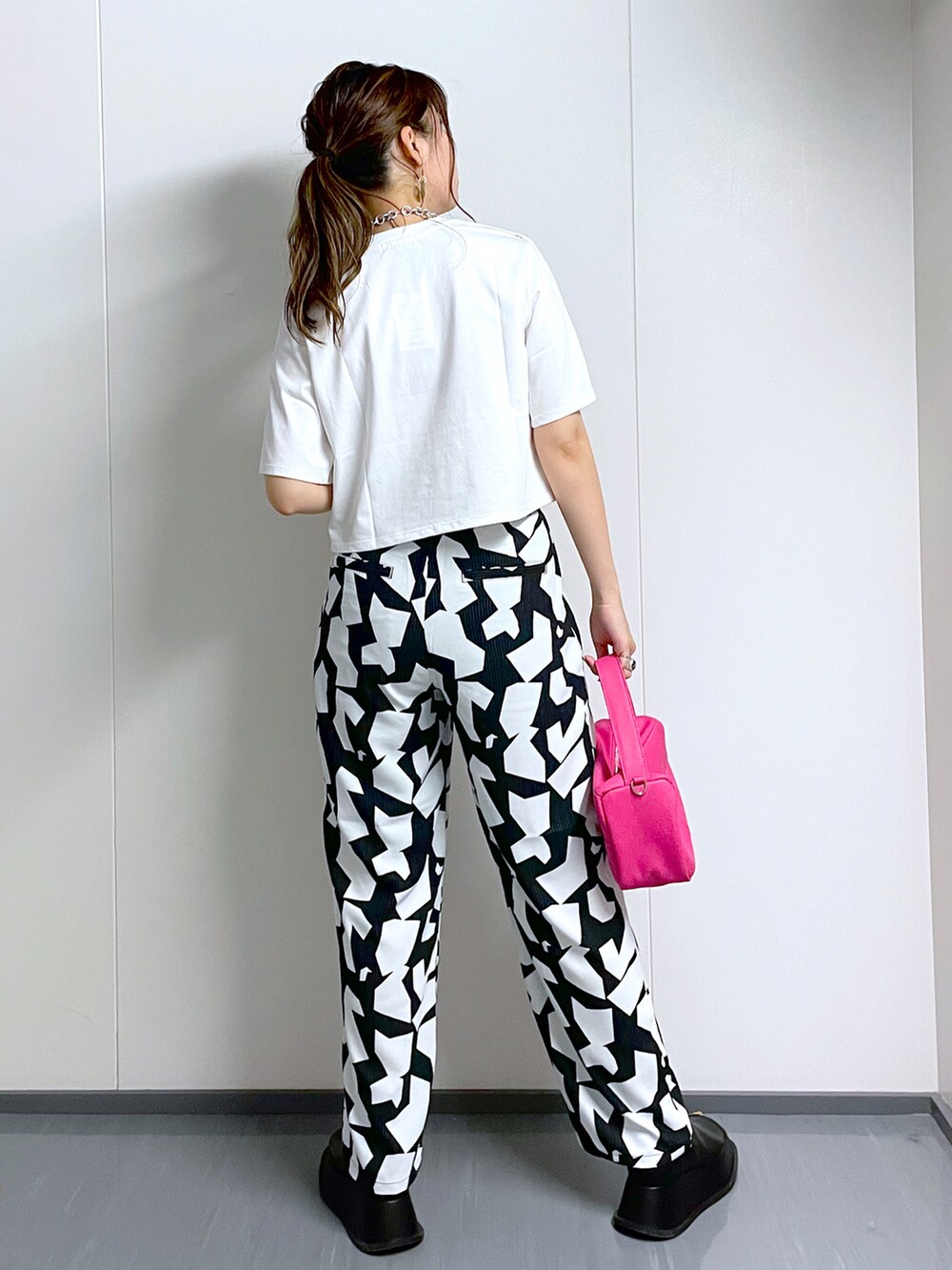 ホワイト系のTシャツ/カットソー、ブラック系のその他パンツ、ピンク系のショルダーバッグを着用したレディースの夏コーディネートの3枚目の写真