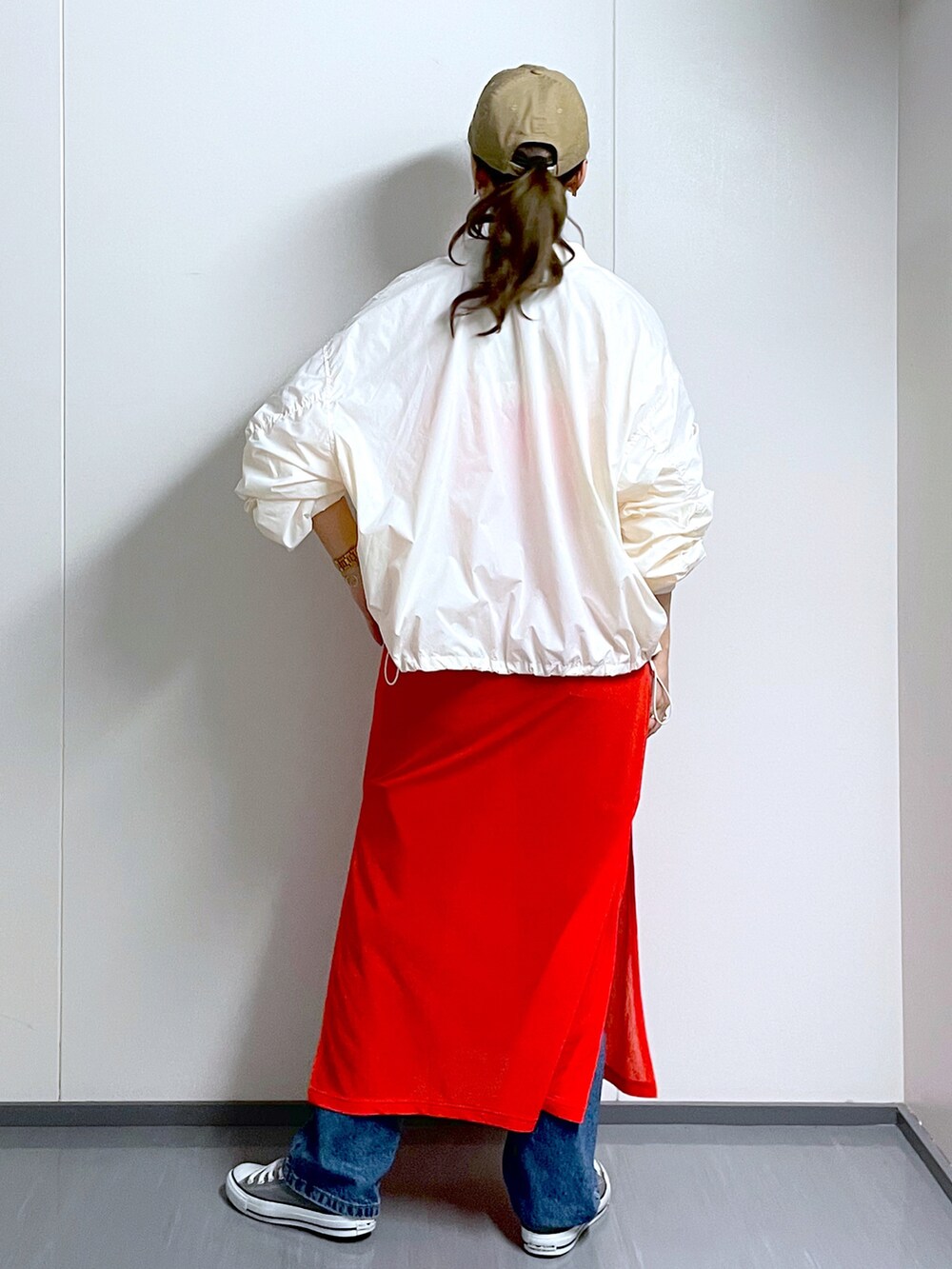 ホワイト系のMA-1、ブラック系のショルダーバッグ、オレンジ系のワンピースを着用したレディースの夏コーディネートの4枚目の写真