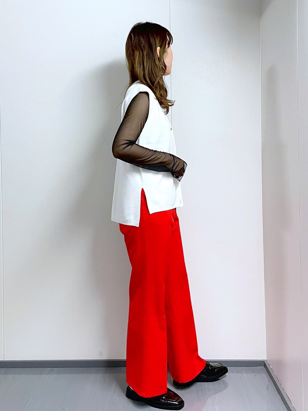 ブラック系のTシャツ/カットソー、ホワイト系のベスト、レッド系のスラックスを着用したレディースの春コーディネートの3枚目の写真