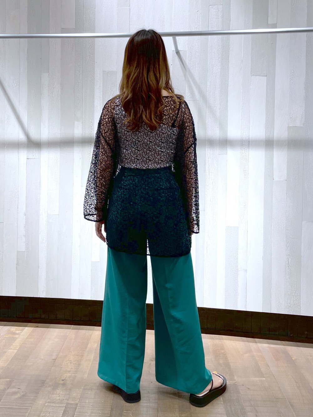 グリーン系のスラックス、ホワイト系のキャミソール、ブラック系のTシャツ/カットソーを着用したレディースの春コーディネートの3枚目の写真