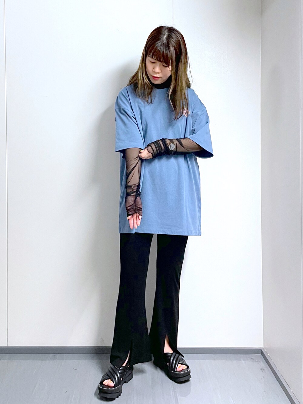 ブルー系のTシャツ/カットソー、ブラック系のスラックス、ブラック系のサンダルを着用したレディースの春コーディネートの2枚目の写真