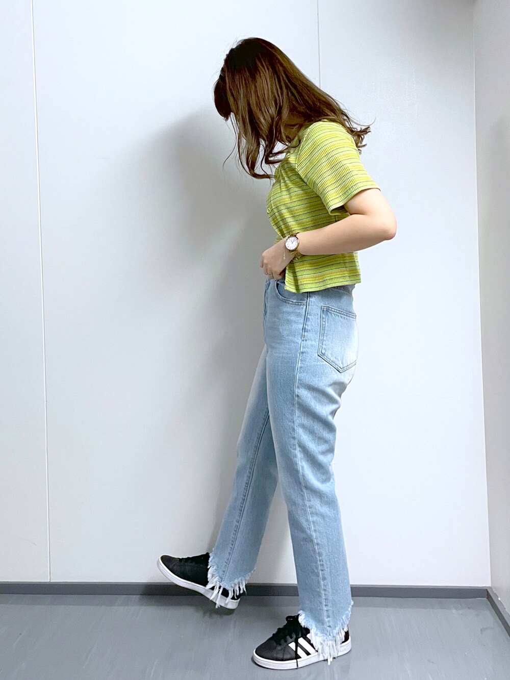 グリーン系のカーディガン/ボレロ、ブルー系のデニムパンツ、ブラック系のベルトを着用したレディースの春コーディネートの2枚目の写真