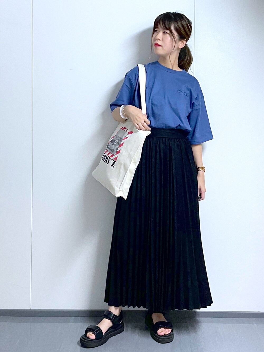 ブラック系のサンダル、ブラック系のスカート、ホワイト系のトートバッグを着用したレディースの夏コーディネートの2枚目の写真