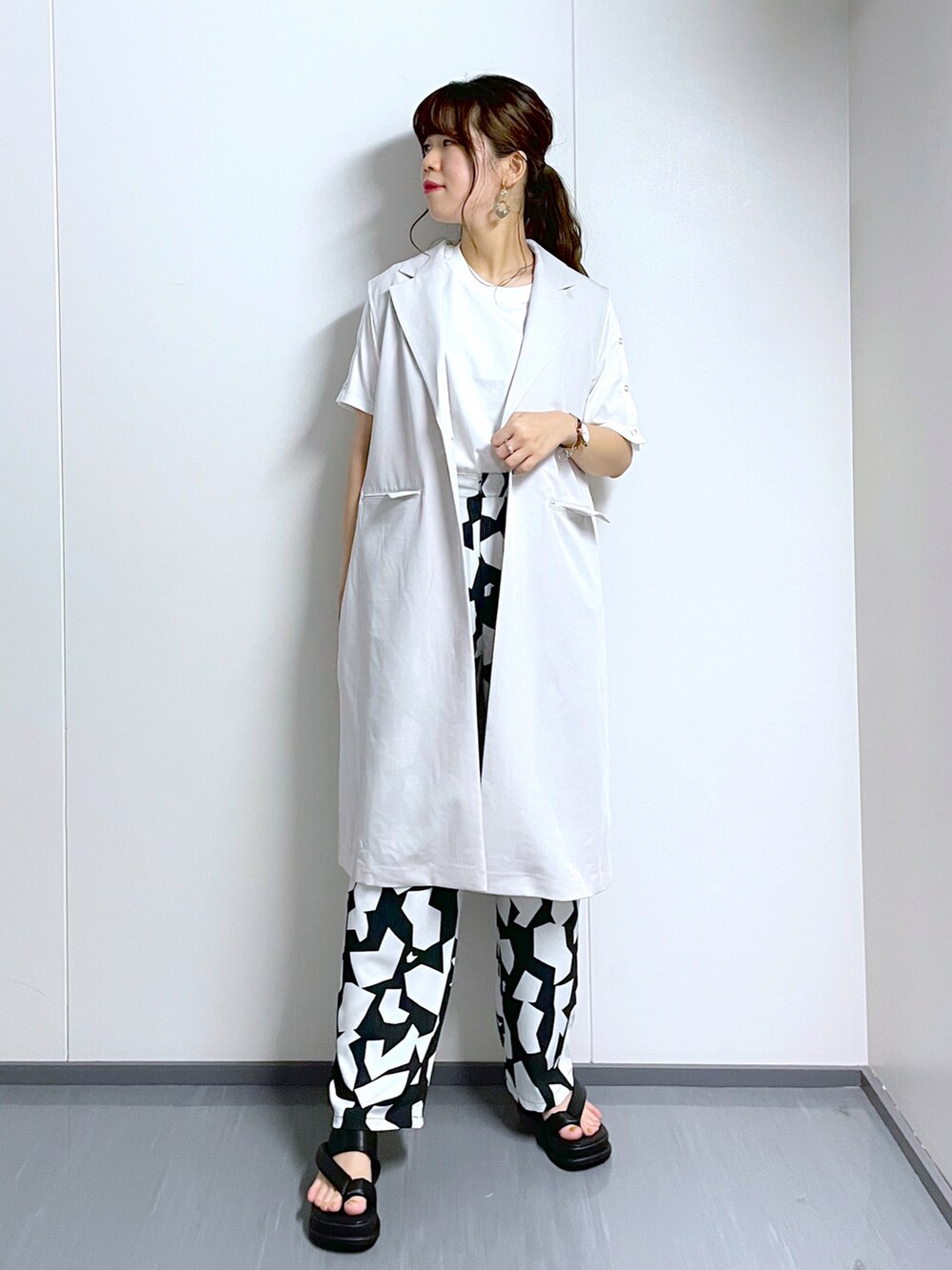 ブラック系のその他パンツ、ホワイト系のTシャツ/カットソー、ブラック系のサンダルを着用したレディースの夏コーディネートの2枚目の写真