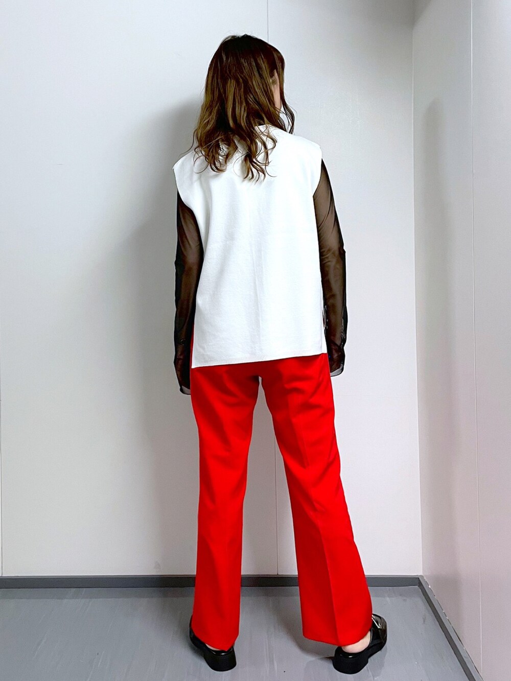 ブラック系のTシャツ/カットソー、ホワイト系のベスト、レッド系のスラックスを着用したレディースの春コーディネートの4枚目の写真
