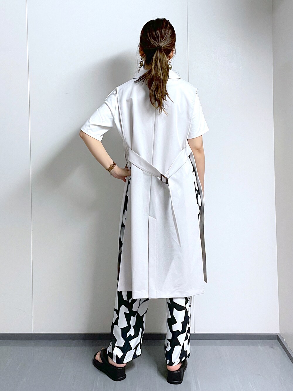 ブラック系のその他パンツ、ホワイト系のTシャツ/カットソー、ブラック系のサンダルを着用したレディースの夏コーディネートの4枚目の写真