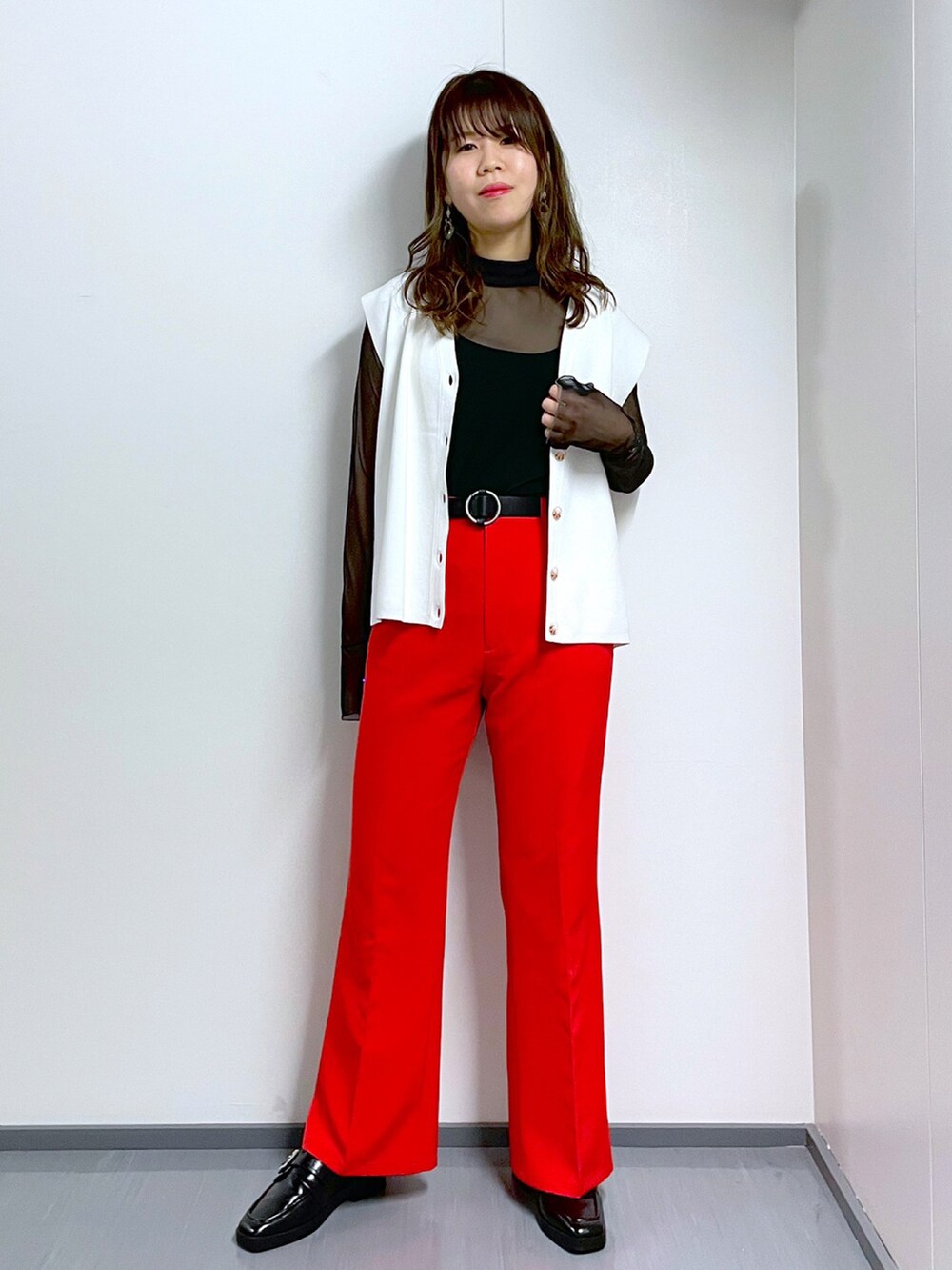 ブラック系のTシャツ/カットソー、ホワイト系のベスト、レッド系のスラックスを着用したレディースの春コーディネートの2枚目の写真