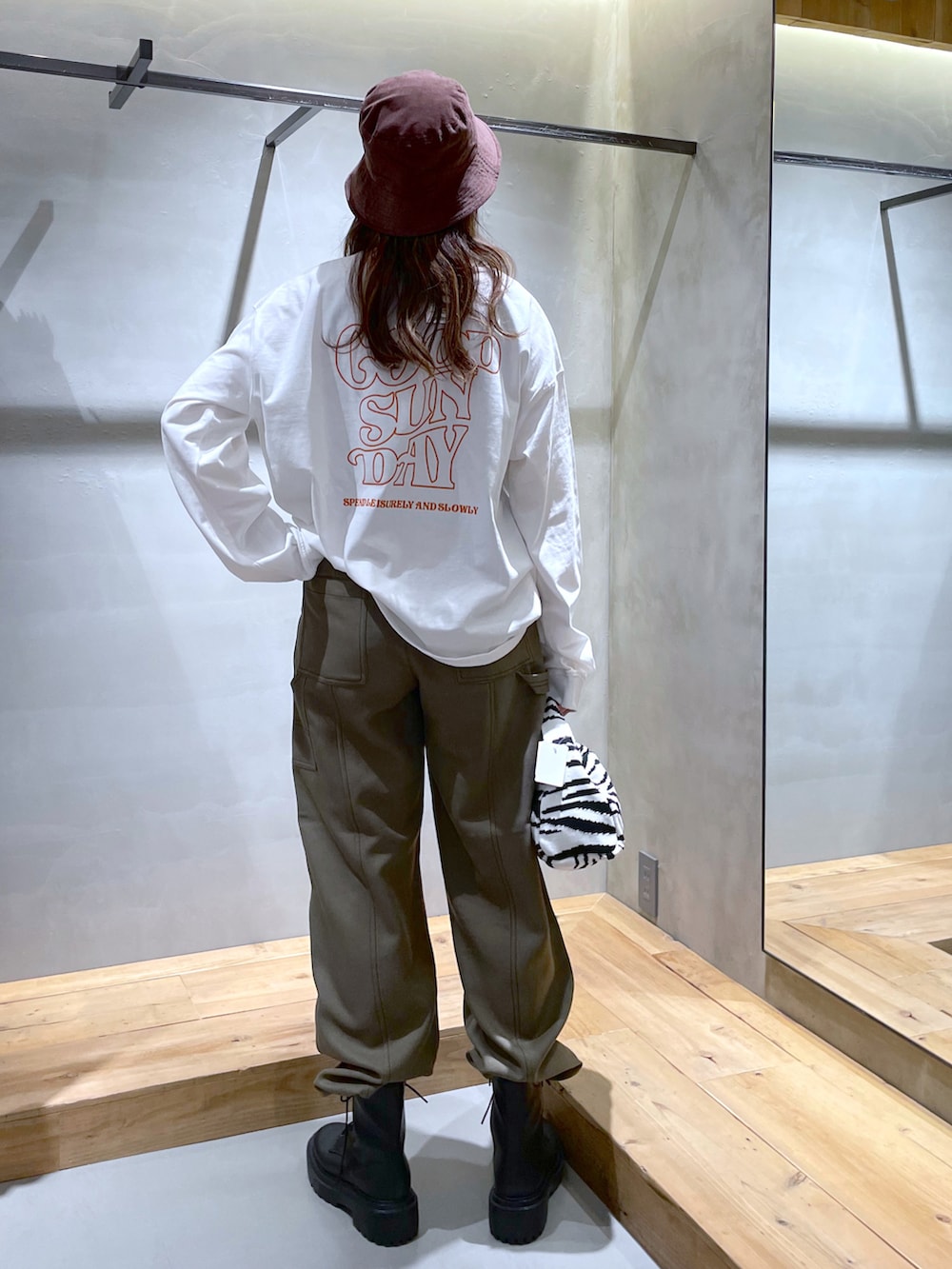 ホワイト系のTシャツ/カットソー、グリーン系のその他パンツ、ブラック系のブーツを着用したレディースの秋コーディネートの3枚目の写真