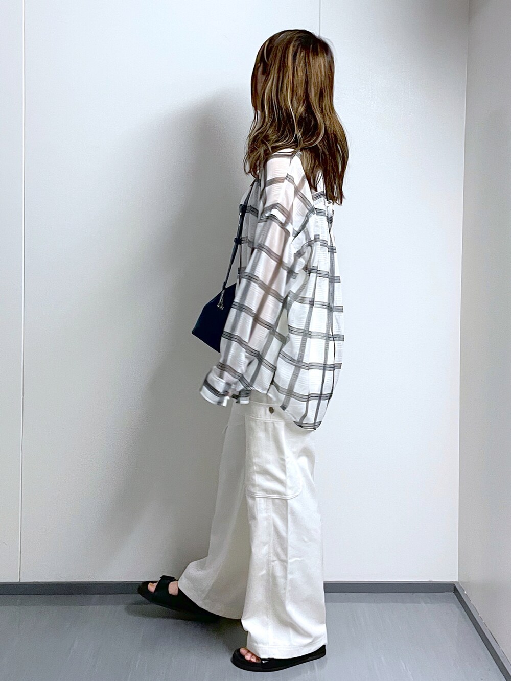 ブルー系のショルダーバッグ、ホワイト系のシャツ/ブラウス、ホワイト系のカーゴパンツを着用したレディースの夏コーディネートの2枚目の写真