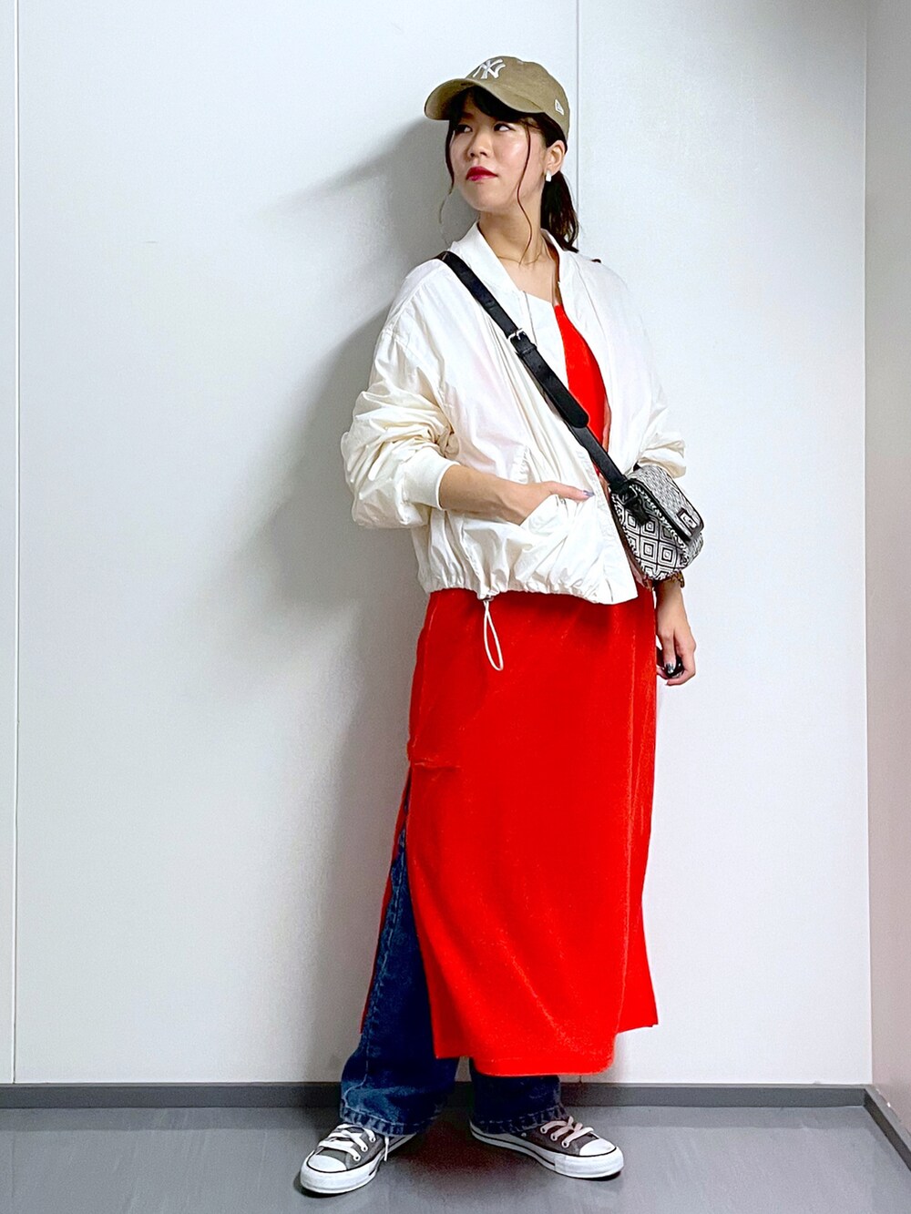 ホワイト系のMA-1、ブラック系のショルダーバッグ、オレンジ系のワンピースを着用したレディースの夏コーディネートの2枚目の写真