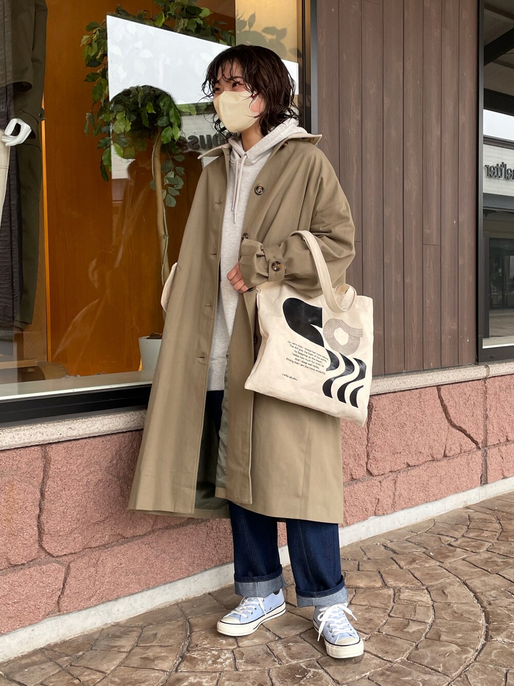 グリーン系のステンカラーコートを着用したレディースの冬コーディネートの2枚目の写真