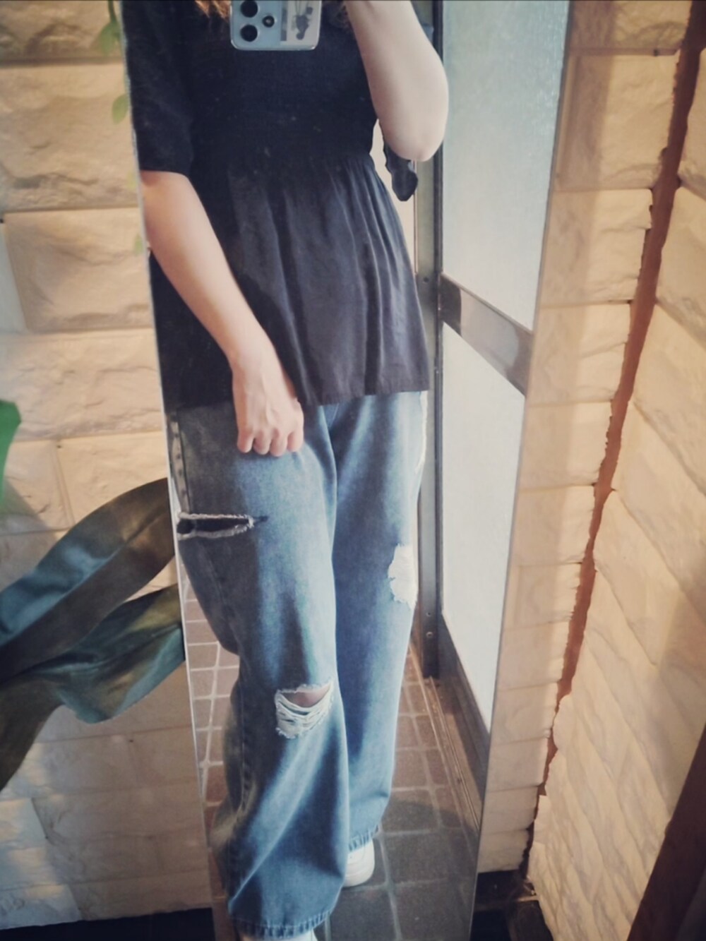 ブラック系のシャツ/ブラウス、ブルー系のデニムパンツ、ホワイト系のスニーカーを着用したレディースの夏コーディネートの2枚目の写真