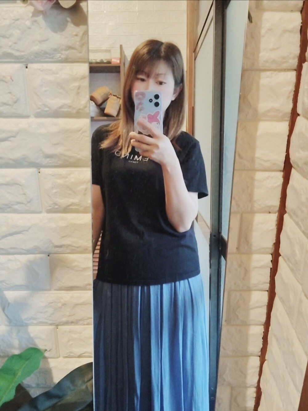 ブラック系のTシャツ/カットソー、ブルー系のスカート、ホワイト系のスニーカーを着用したレディースの夏コーディネートの2枚目の写真