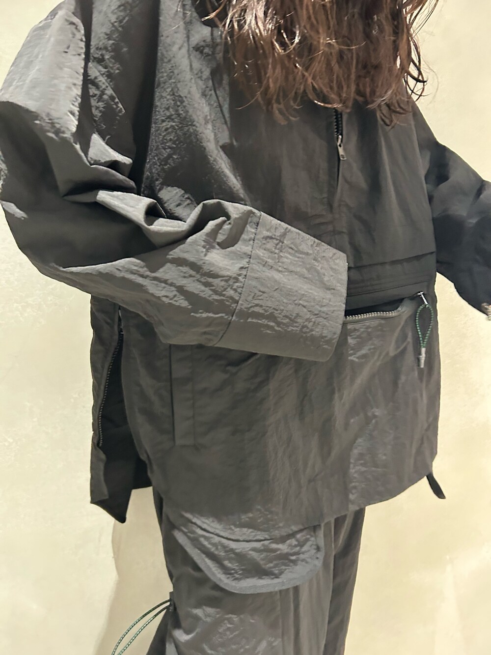 ブラック系のマウンテンパーカー、ブラック系のスカート、その他のサンダルを着用したレディースの春コーディネートの6枚目の写真