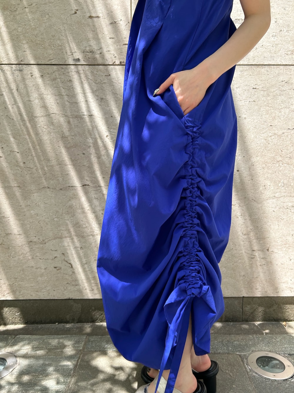 ブルー系のワンピース、シルバー系のサンダル、ベージュ系のハットを着用したレディースの春コーディネートの5枚目の写真