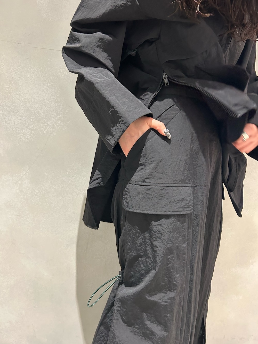 ブラック系のマウンテンパーカー、ブラック系のスカート、その他のサンダルを着用したレディースの春コーディネートの8枚目の写真