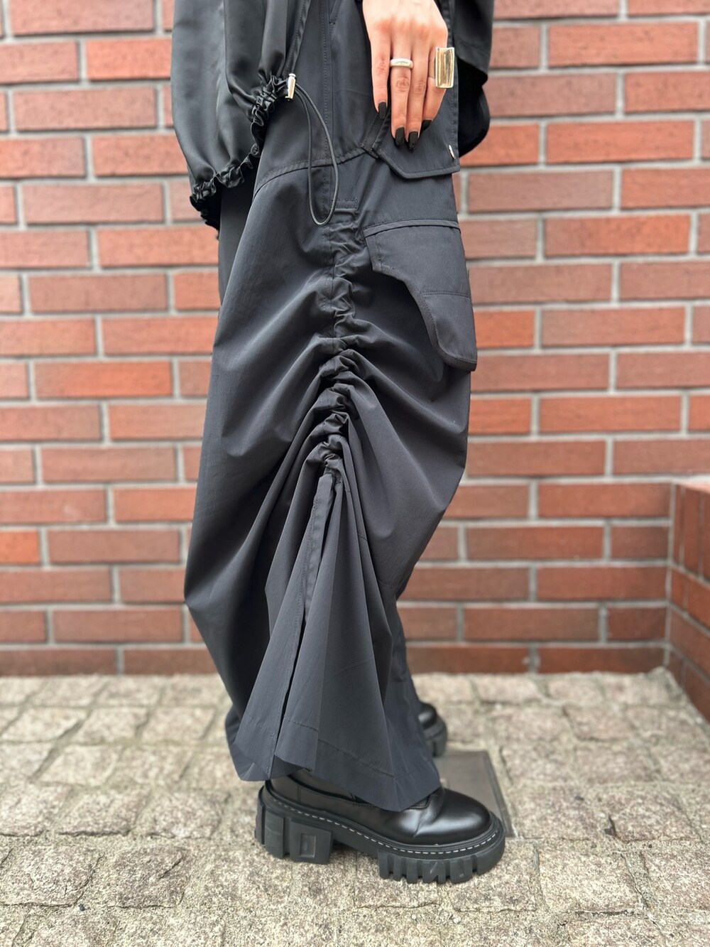 ブラック系のTシャツ/カットソー、ブラック系のスカート、ブラック系のローファーを着用したレディースの秋コーディネートの6枚目の写真