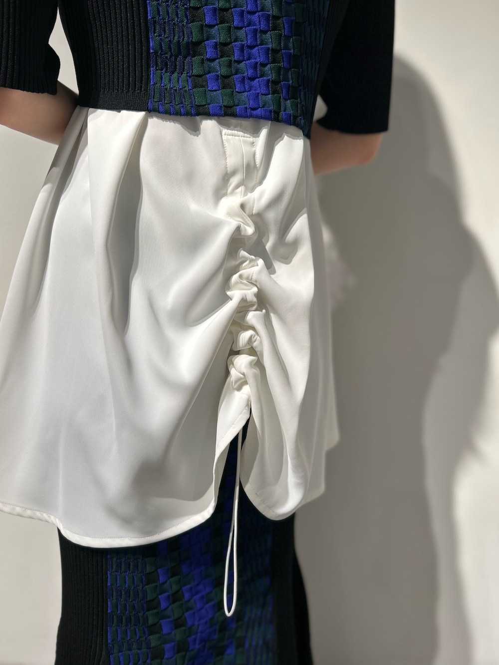 シルバー系のブーツ、ブラック系のスカート、ホワイト系のタンクトップを着用したレディースの冬コーディネートの8枚目の写真