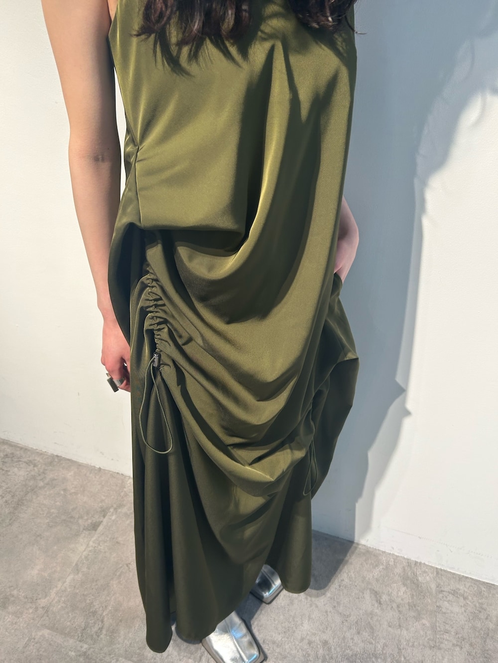 グリーン系のワンピース、ホワイト系のタンクトップ、シルバー系のパンプスを着用したレディースの春コーディネートの5枚目の写真