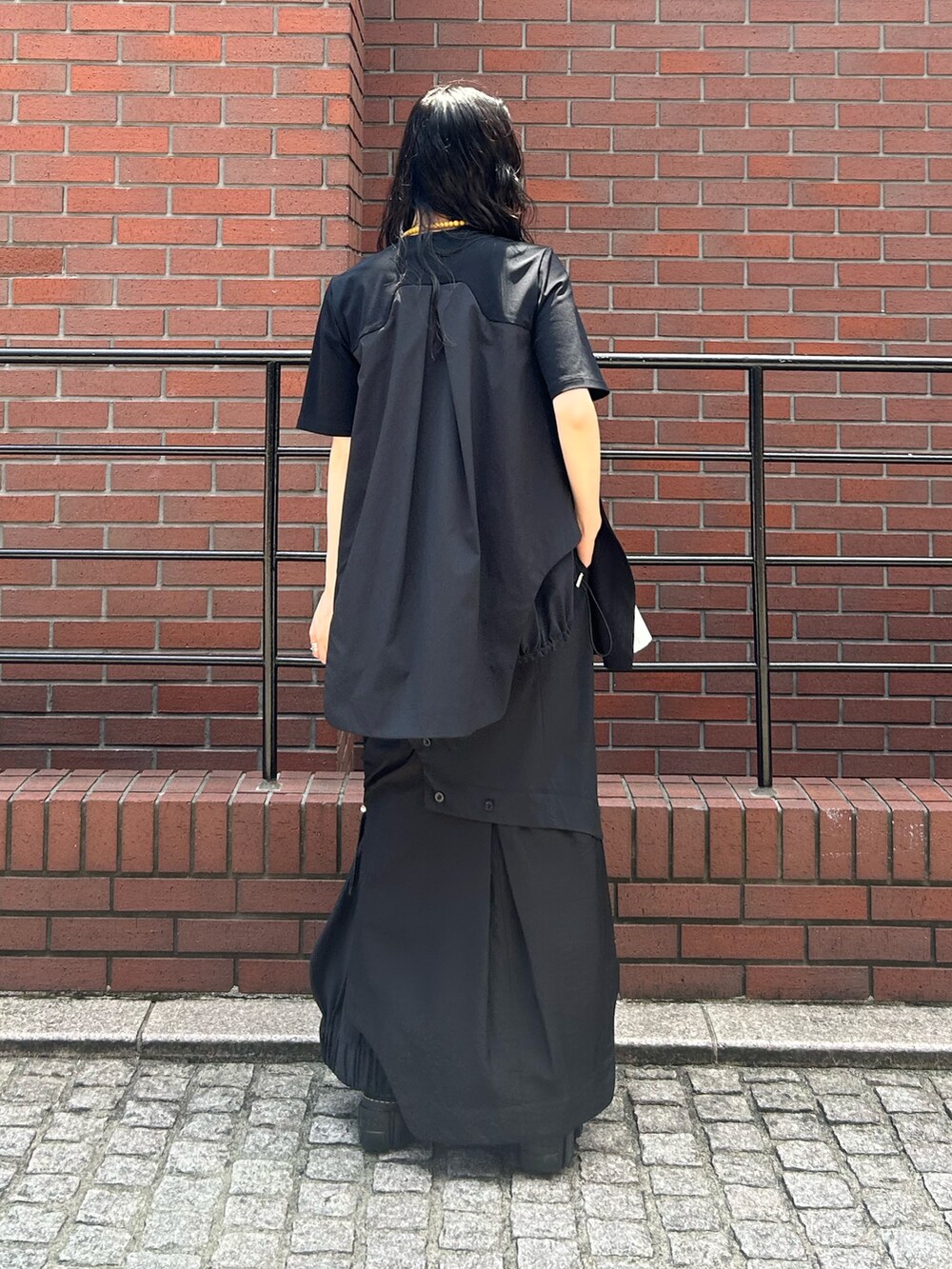 ブラック系のスカート、ブラック系のTシャツ/カットソー、ブラック系のブーツを着用したレディースの夏コーディネートの3枚目の写真