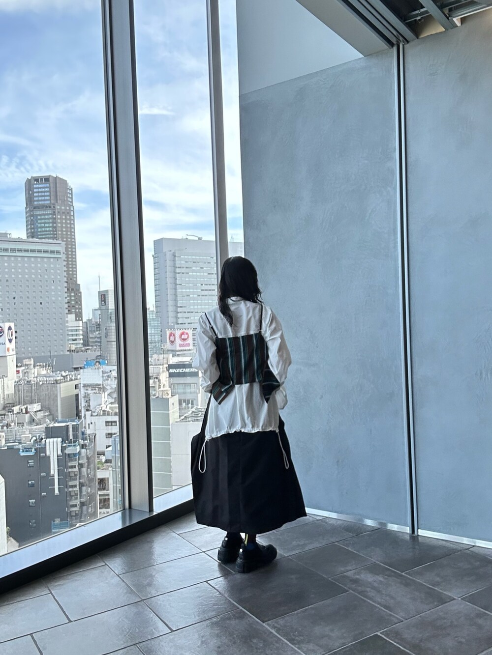 ホワイト系のシャツ/ブラウス、ブラウン系のキャミソール、ブラック系のスカートを着用したレディースの夏コーディネートの6枚目の写真