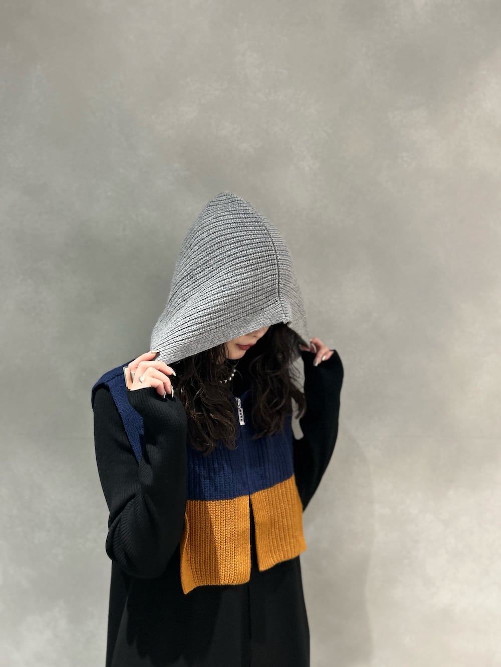 ブラック系のワンピース、ブラック系のブーツ、グレー系のネックウォーマー/スヌードを着用したレディースの冬コーディネートの4枚目の写真