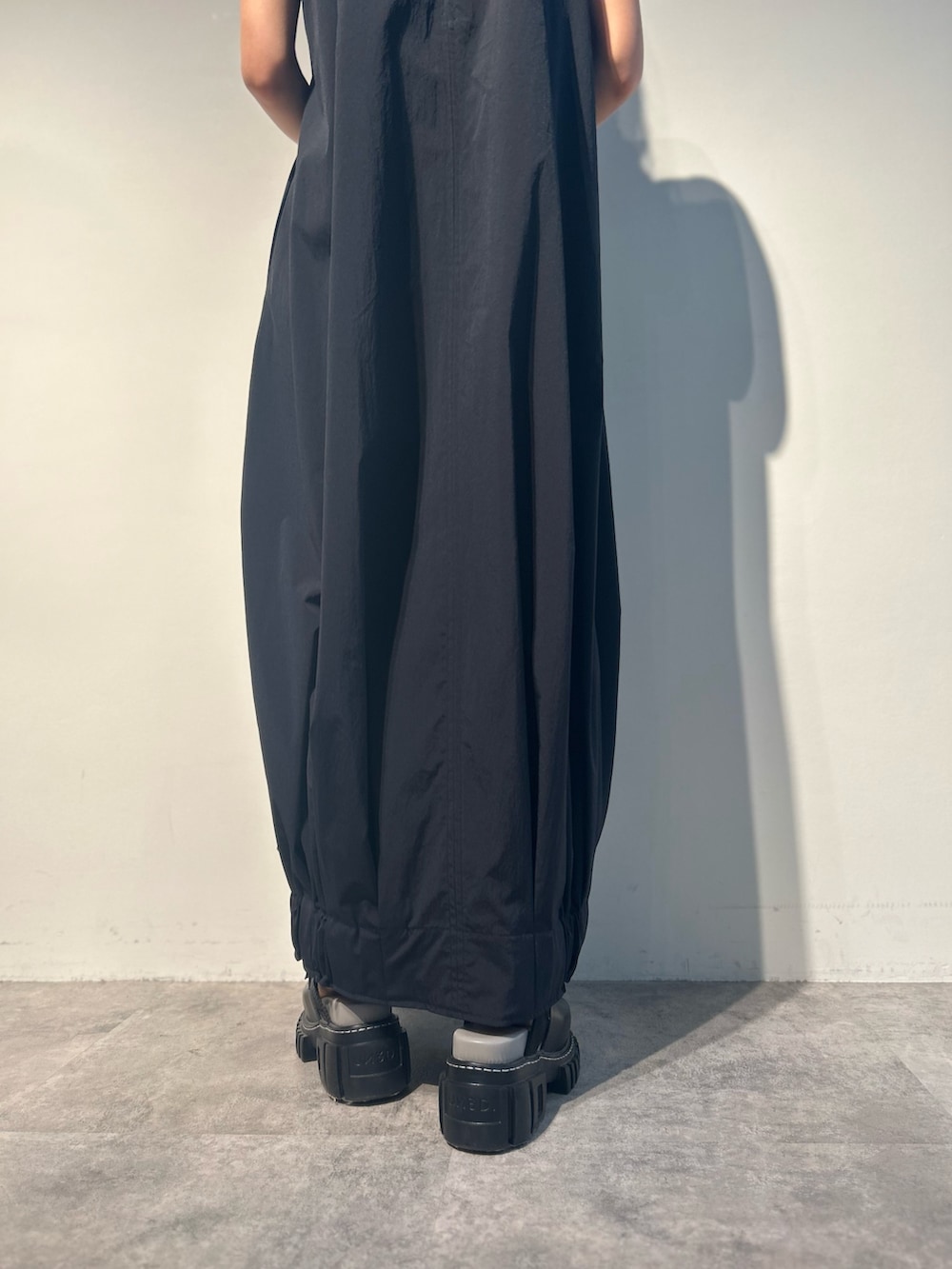 ブラック系のワンピース、グリーン系のトートバッグ、その他のサンダルを着用したレディースの夏コーディネートの6枚目の写真