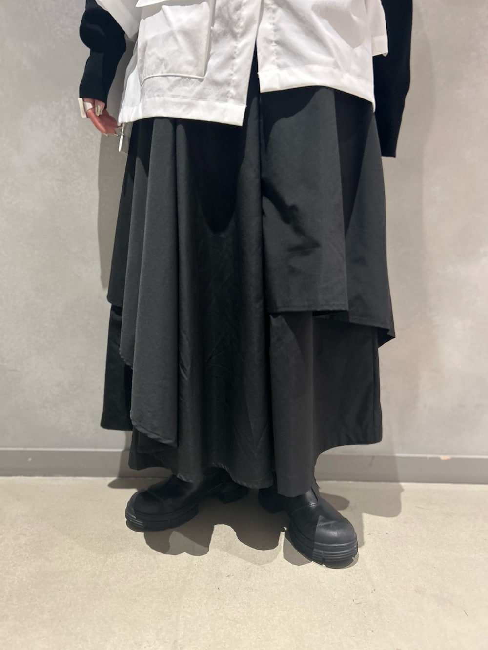 ブラック系のその他パンツ、ブラック系のニット/セーター、ブラウン系のネックレスを着用したレディースの冬コーディネートの6枚目の写真