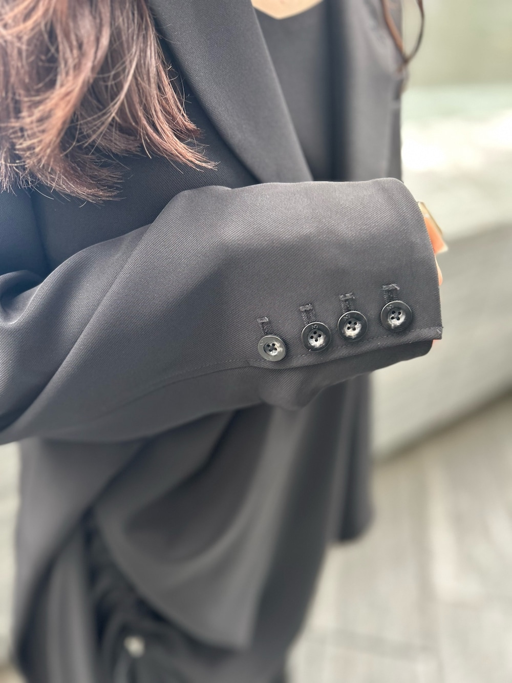 ブラック系のワンピース、ブラック系のテーラードジャケット、シルバー系のブーツを着用したレディースの春コーディネートの6枚目の写真