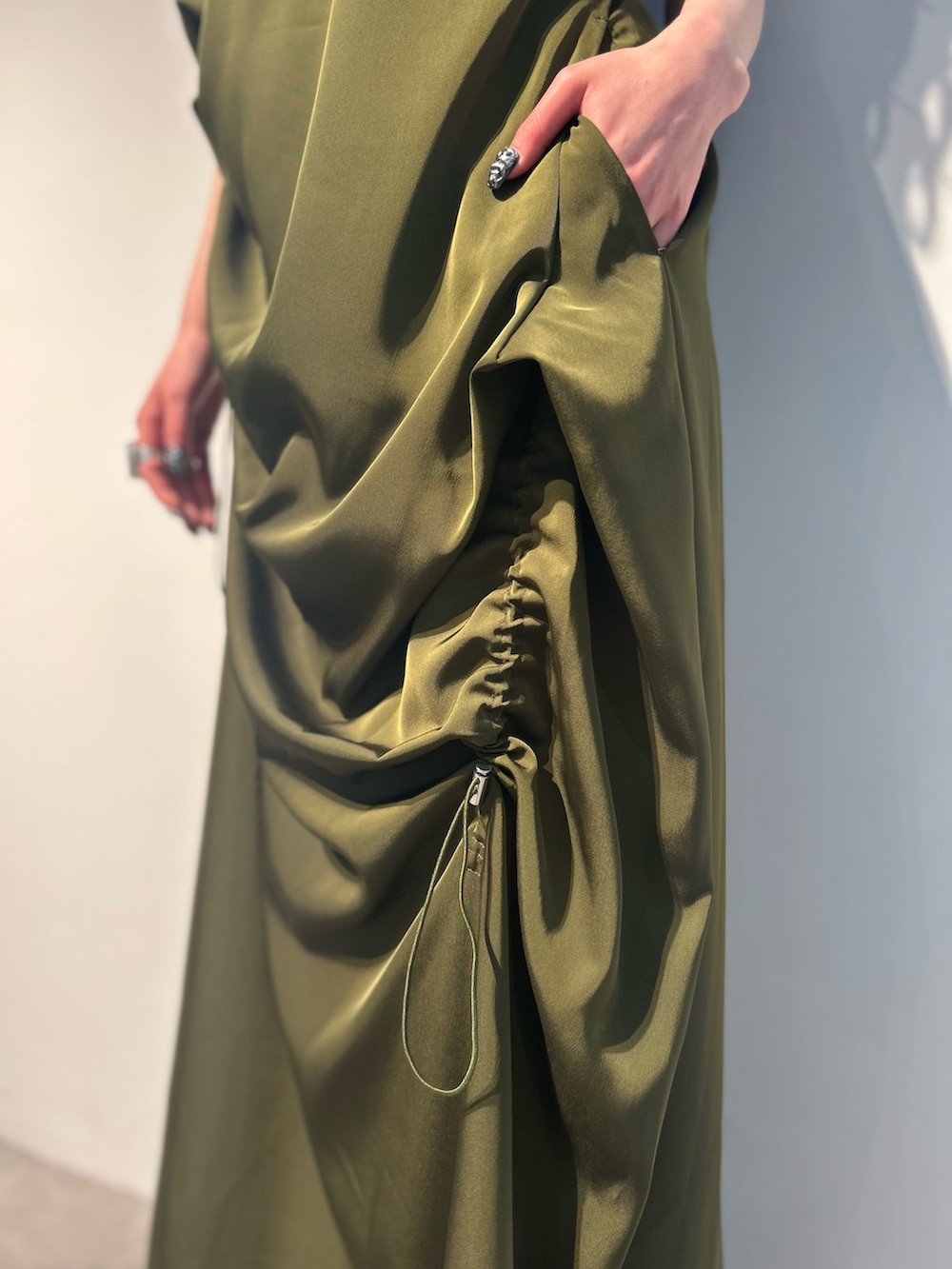 グリーン系のワンピース、ホワイト系のタンクトップ、シルバー系のパンプスを着用したレディースの春コーディネートの6枚目の写真