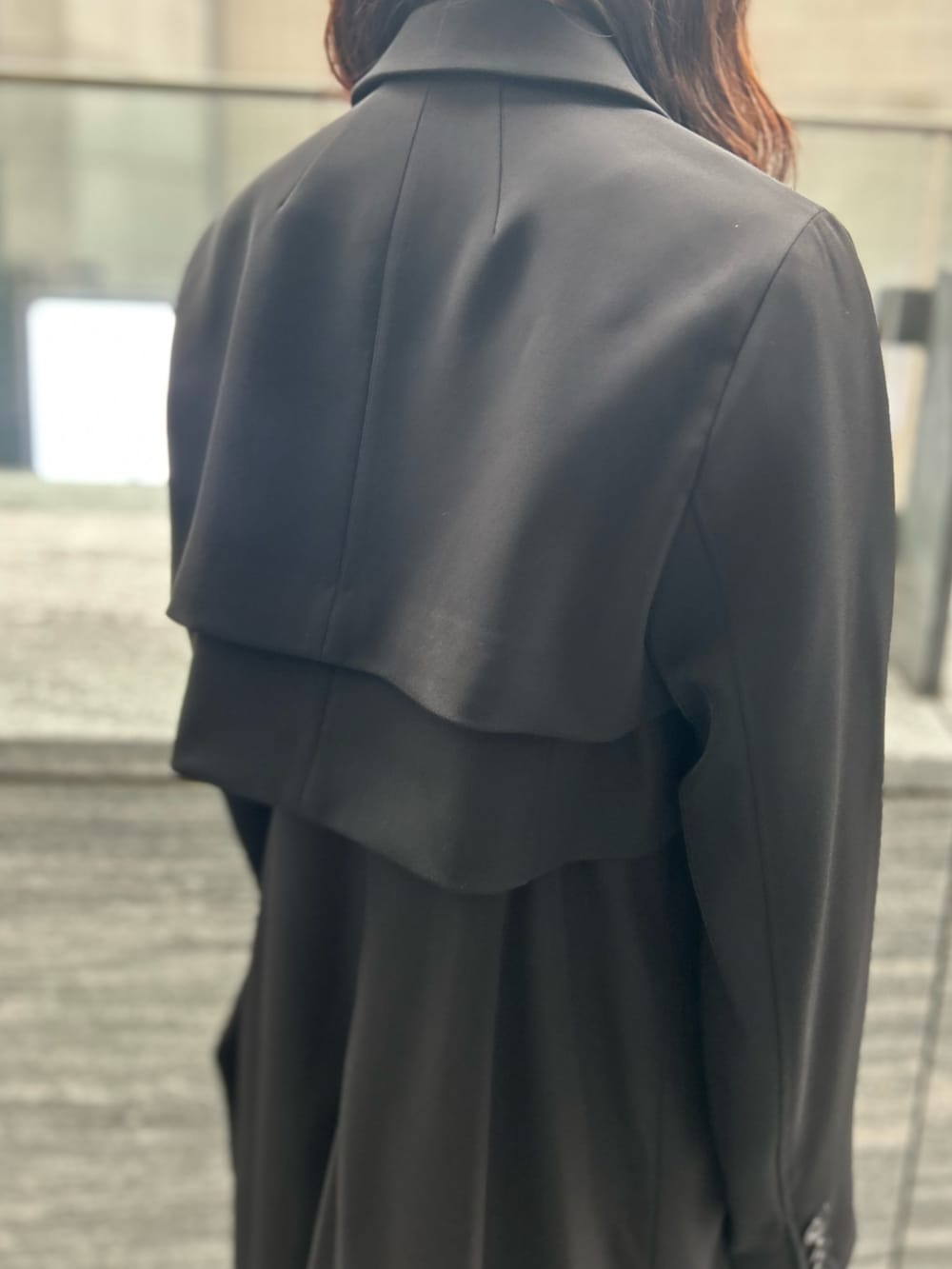 ブラック系のワンピース、ブラック系のテーラードジャケット、シルバー系のブーツを着用したレディースの春コーディネートの4枚目の写真