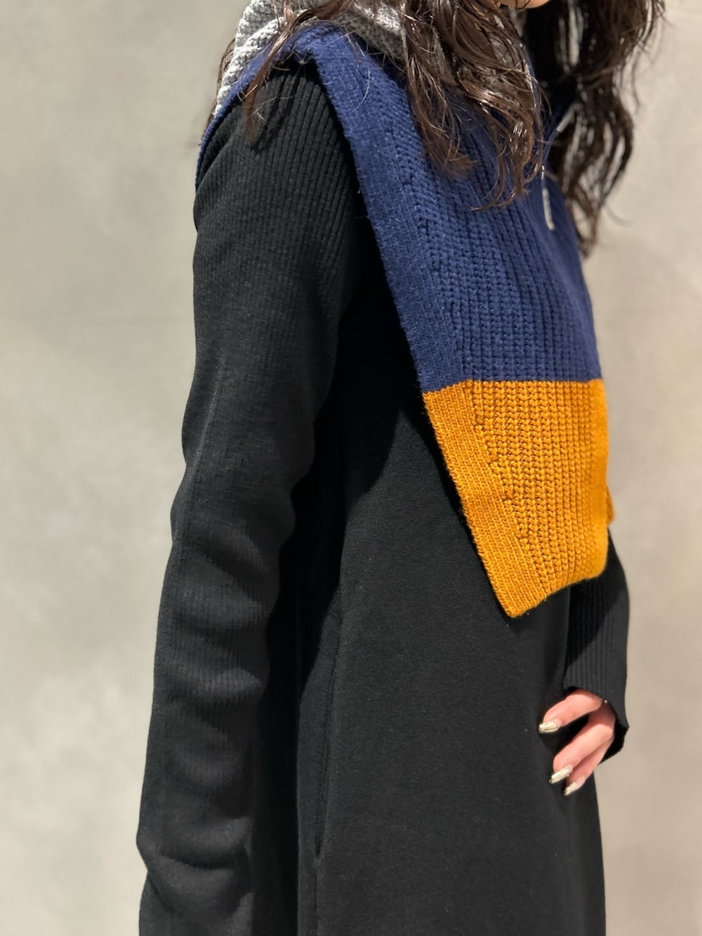 ブラック系のワンピース、ブラック系のブーツ、グレー系のネックウォーマー/スヌードを着用したレディースの冬コーディネートの6枚目の写真