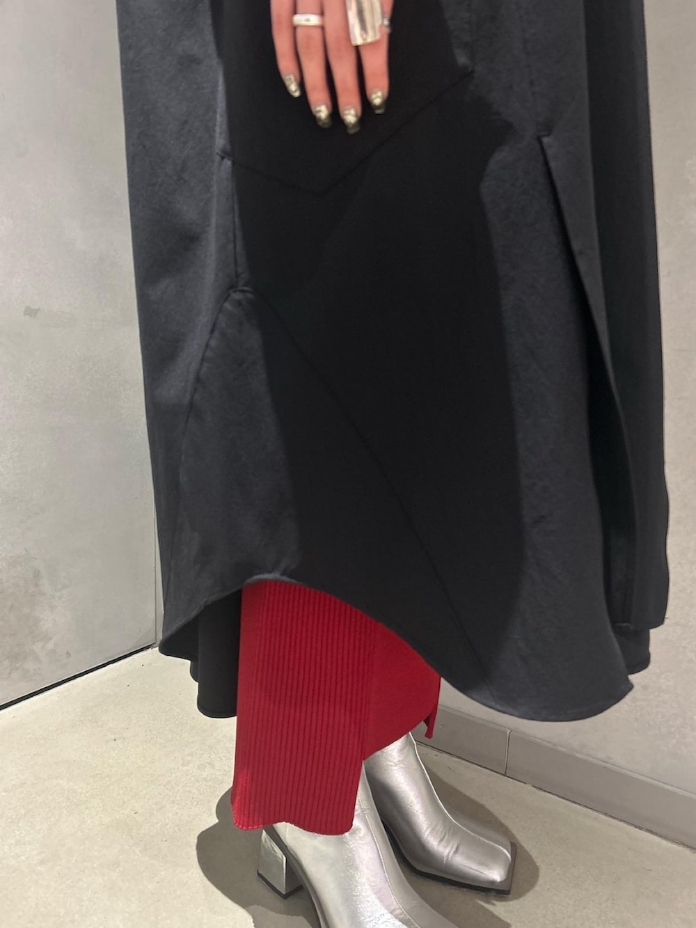 ブラック系のワンピース、レッド系のスカート、シルバー系のブーツを着用したレディースの冬コーディネートの9枚目の写真