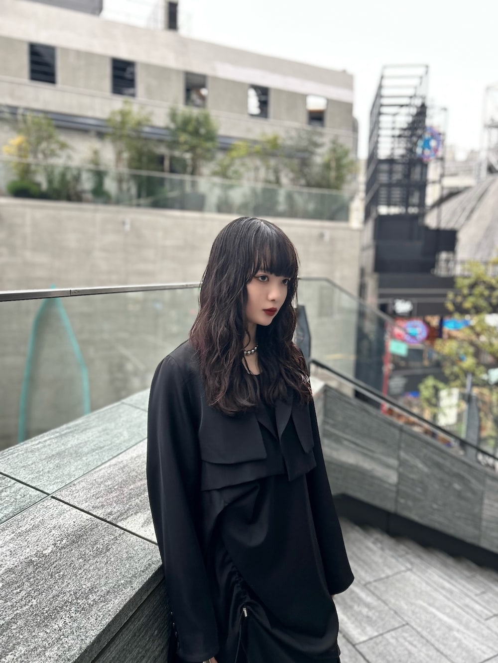 ブラック系のワンピース、ブラック系のテーラードジャケット、シルバー系のブーツを着用したレディースの春コーディネートの2枚目の写真