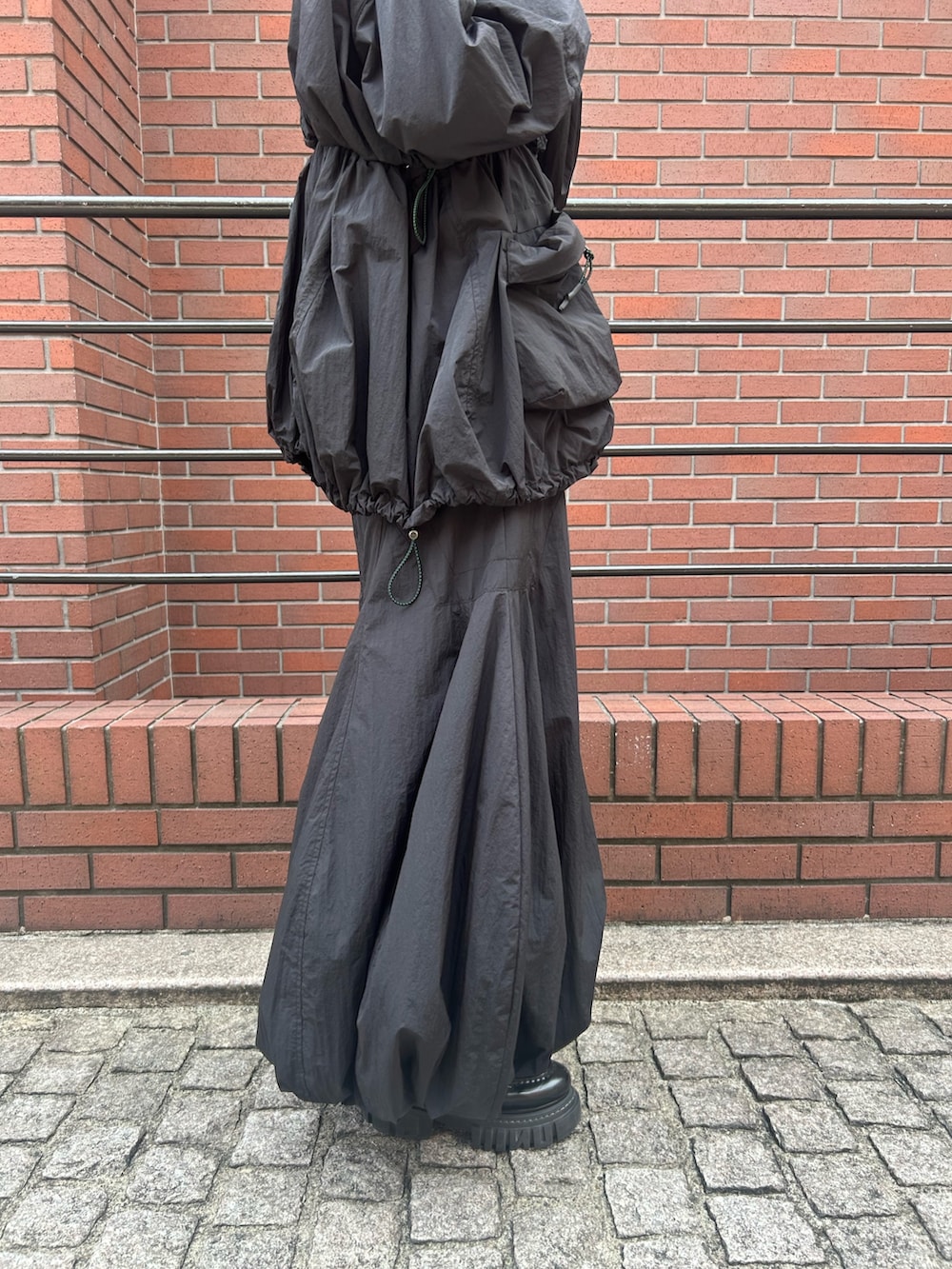 ブラック系のブルゾン、ブラック系のスカートを着用したレディースの夏コーディネートの9枚目の写真