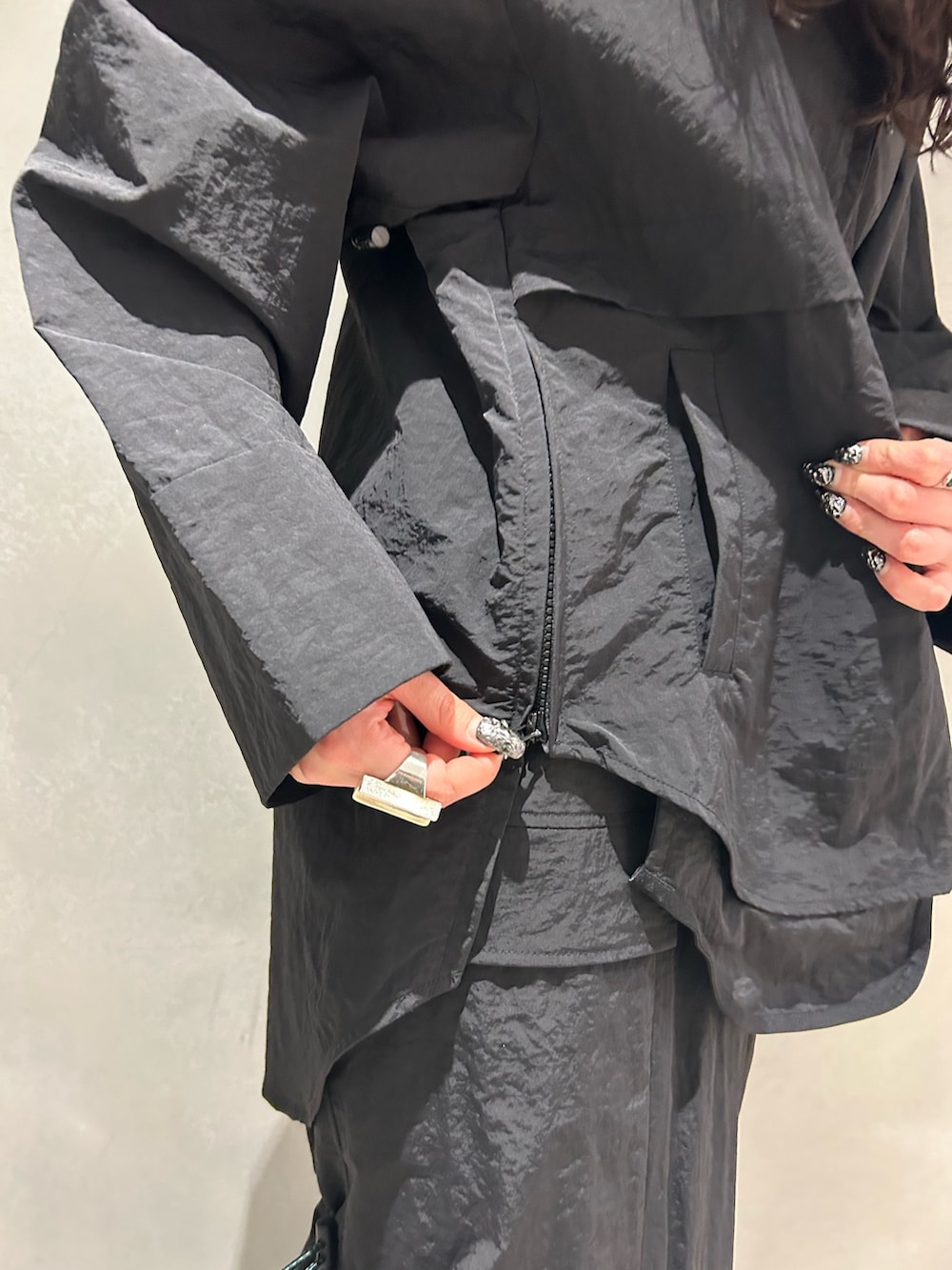 ブラック系のマウンテンパーカー、ブラック系のスカート、その他のサンダルを着用したレディースの春コーディネートの9枚目の写真