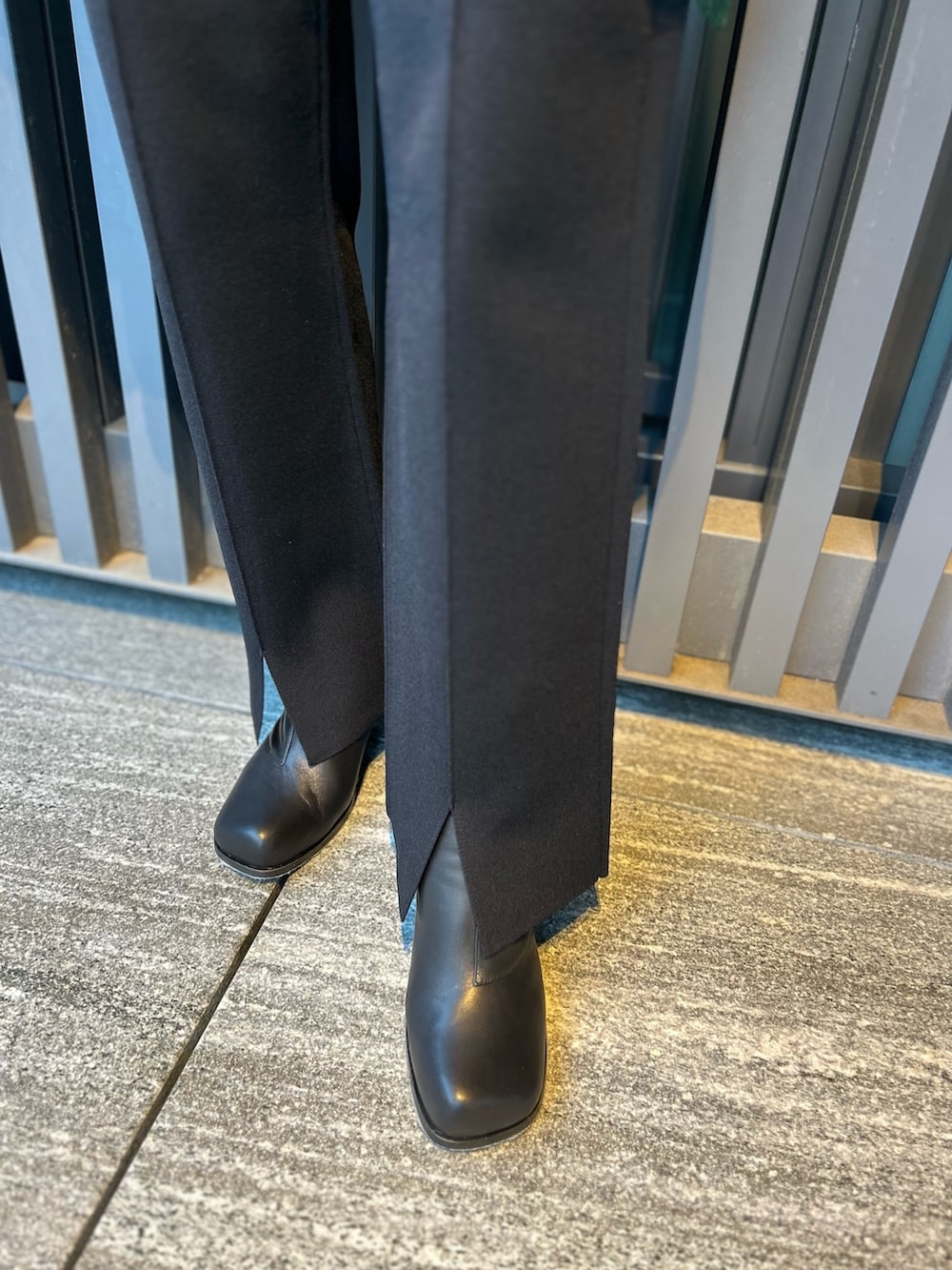 ブラック系のニット/セーター、ブラック系のその他パンツ、ブラック系のブーツを着用したレディースの秋コーディネートの9枚目の写真