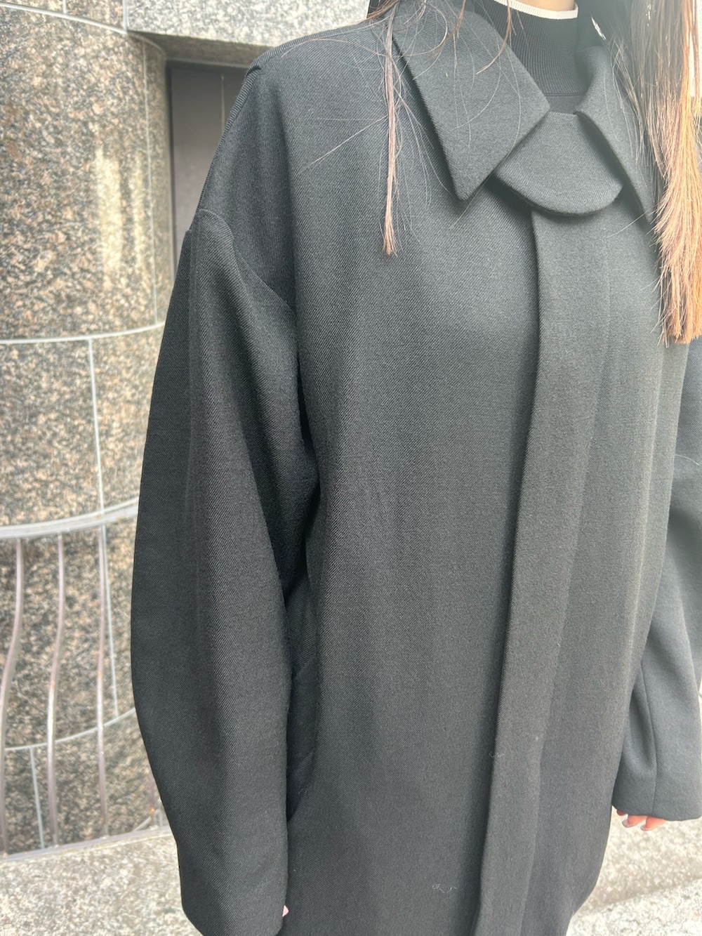 ブラック系のステンカラーコート、ブラック系のブーツを着用したレディースの秋コーディネートの4枚目の写真