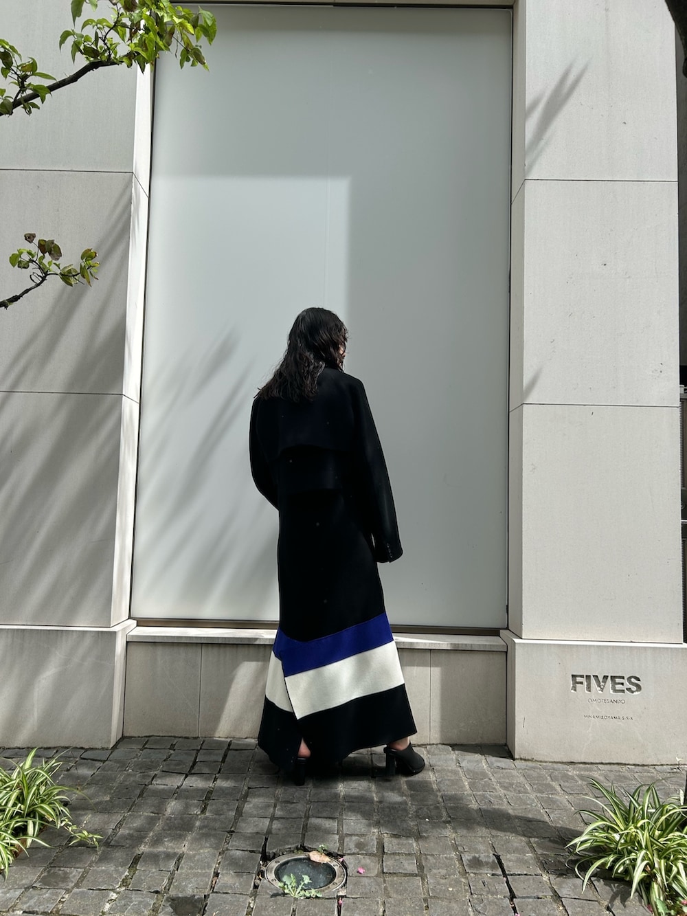 グレー系のテーラードジャケット、ホワイト系のワンピース、ブラック系のパンプスを着用したレディースの夏コーディネートの2枚目の写真