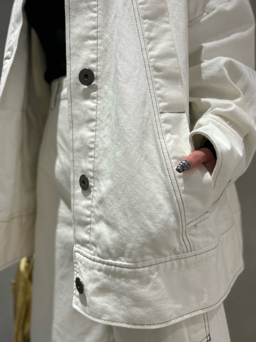 ホワイト系のデニムパンツ、ホワイト系のデニムジャケット、ブラック系のニット/セーターを着用したレディースの春コーディネートの7枚目の写真