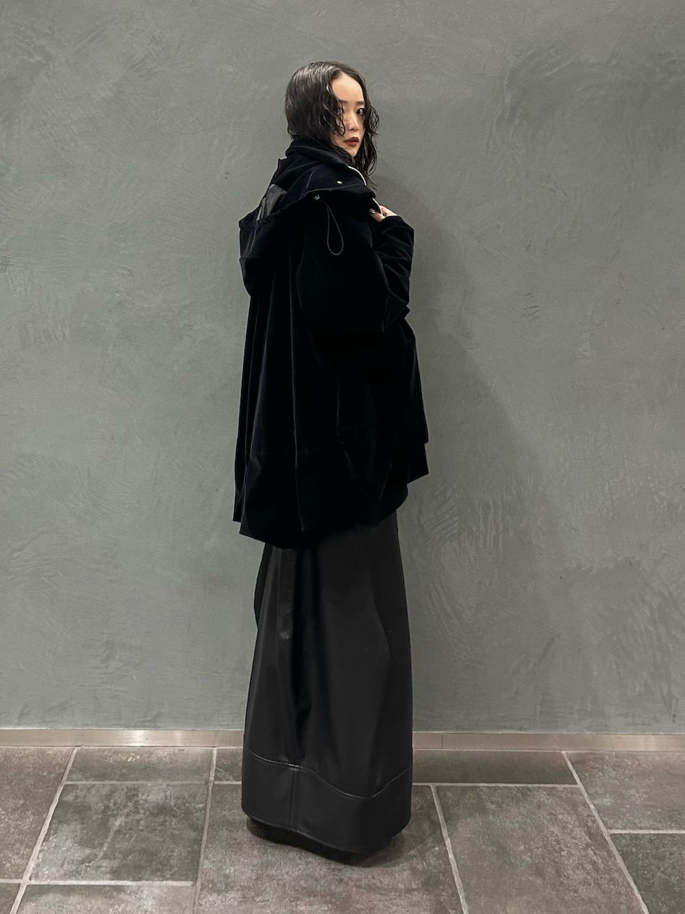 ブラック系のその他アウター、ブラック系のニット/セーター、ブラック系のスカートを着用したレディースの秋コーディネートの2枚目の写真