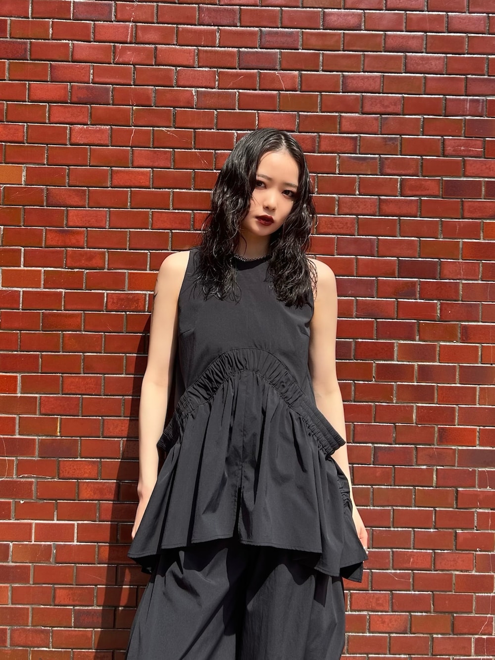 ブラック系のその他パンツ、ブラック系のタンクトップ、シルバー系のネックレスを着用したレディースの春コーディネートの2枚目の写真