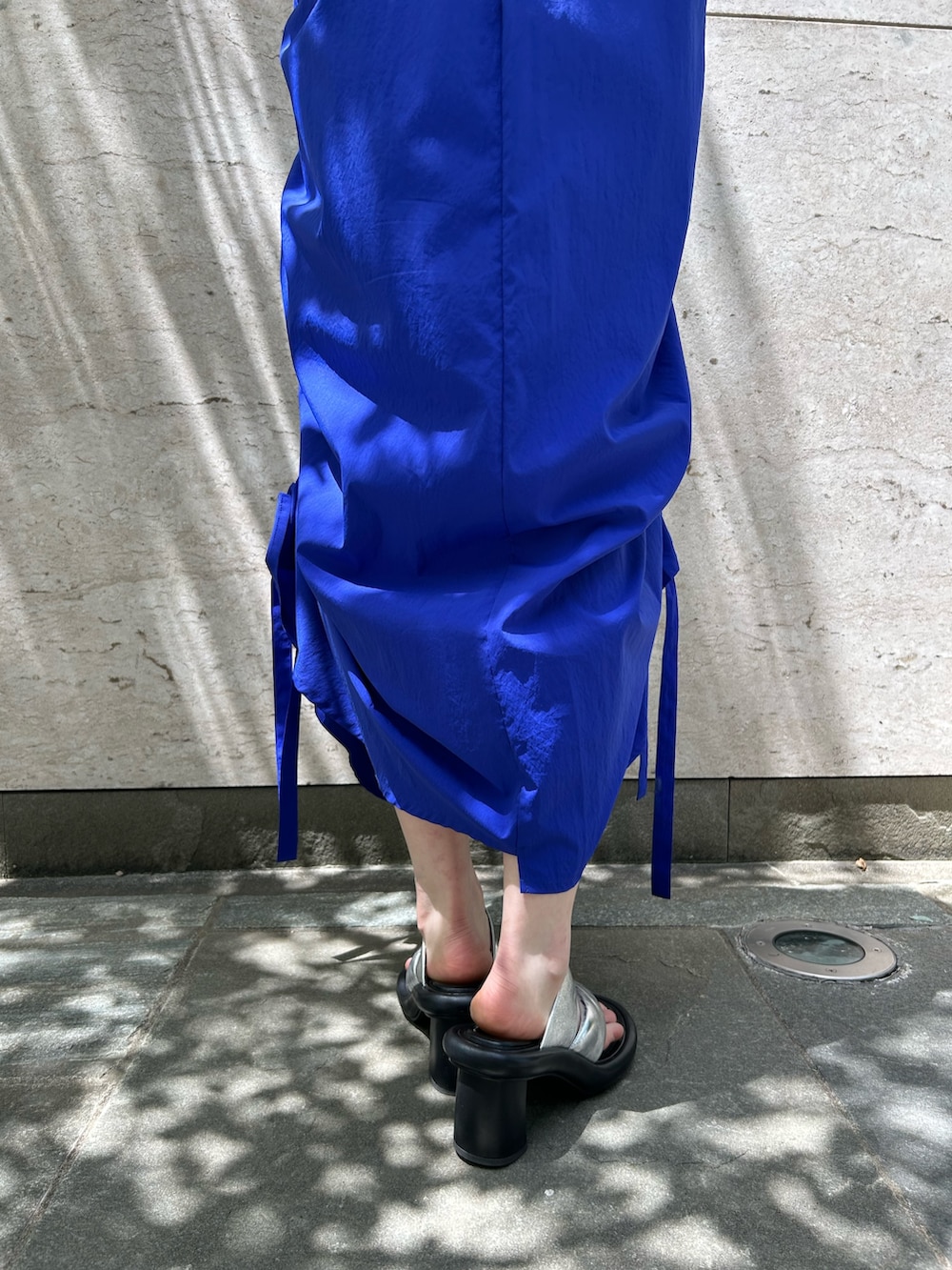 ブルー系のワンピース、シルバー系のサンダル、ベージュ系のハットを着用したレディースの春コーディネートの7枚目の写真