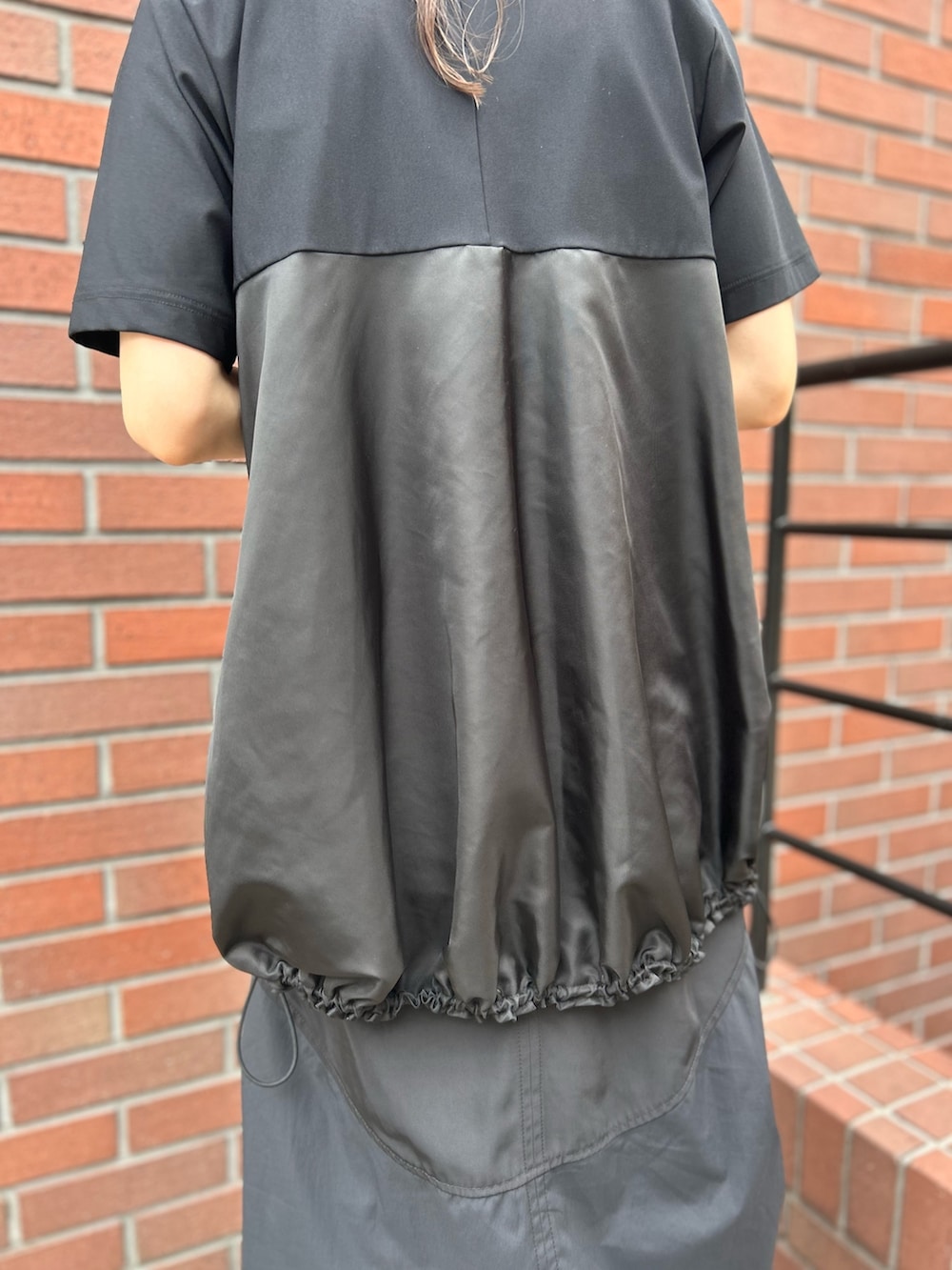 ブラック系のTシャツ/カットソー、ブラック系のスカート、ブラック系のローファーを着用したレディースの秋コーディネートの9枚目の写真